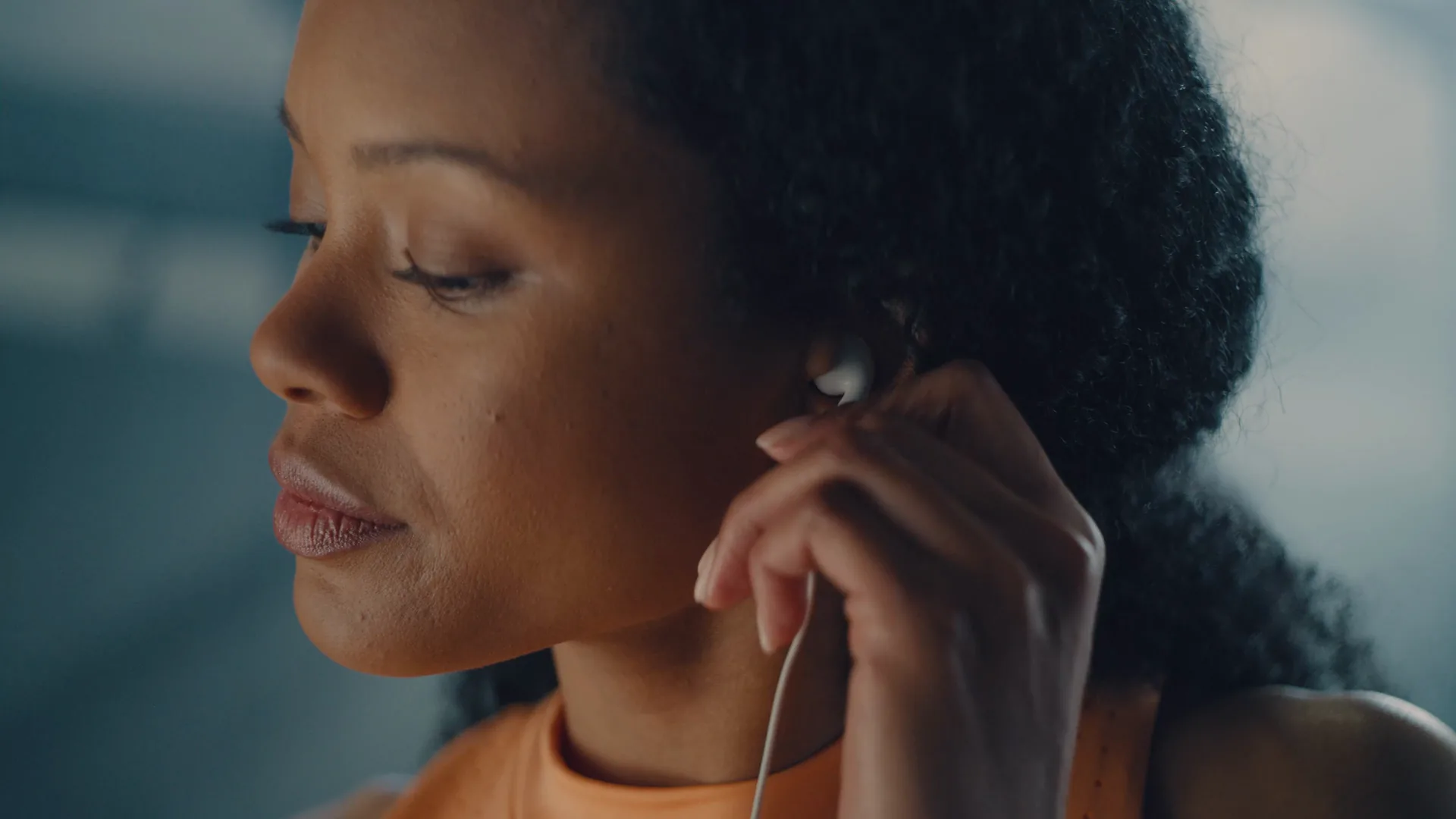 Woman putting in an earbud before a workout