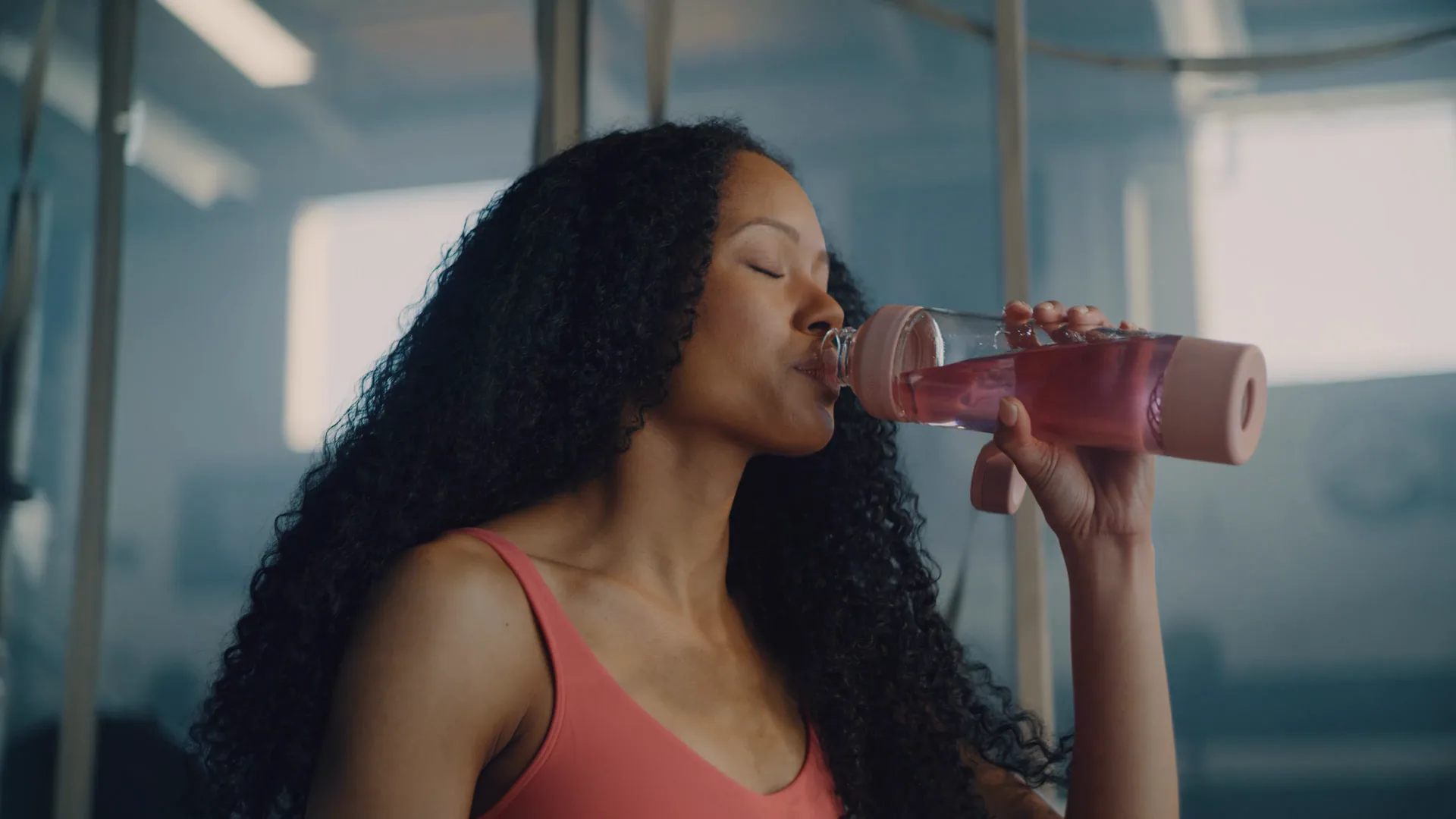 Woman drinking from a shaker after training