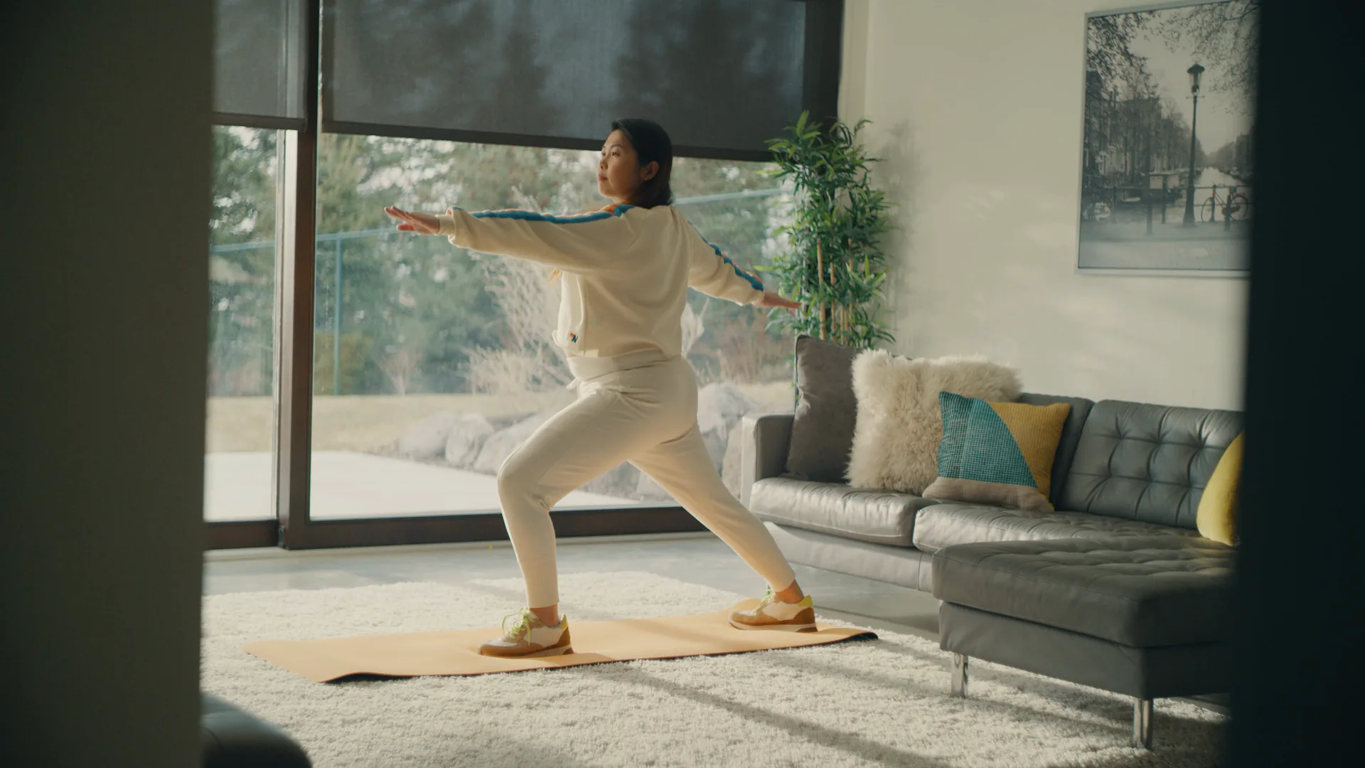 Woman holding a yoga pose in a bright living room