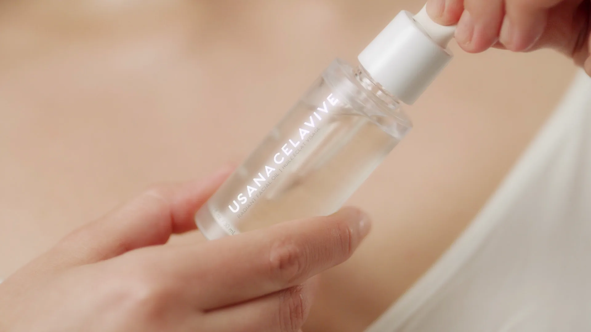 Dropper bottle of facial oil against skin