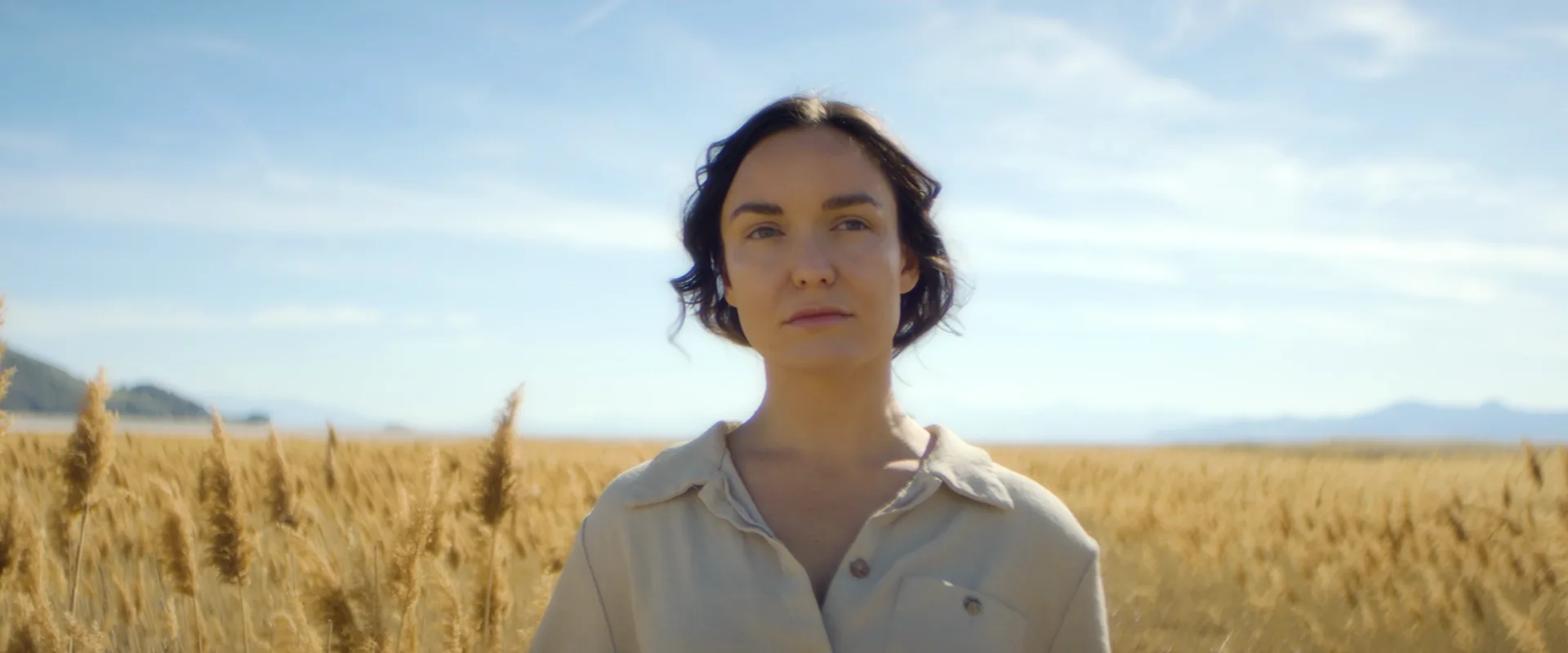 Woman standing in a field of golden grass