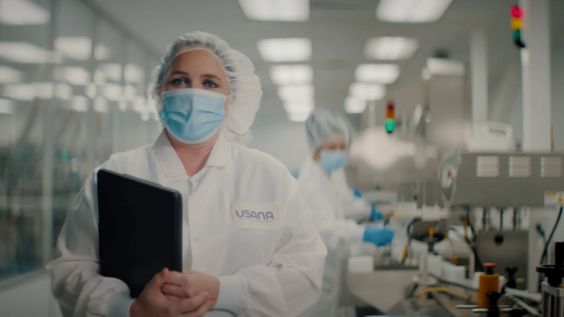 USANA lab technician with a tablet on the production floor